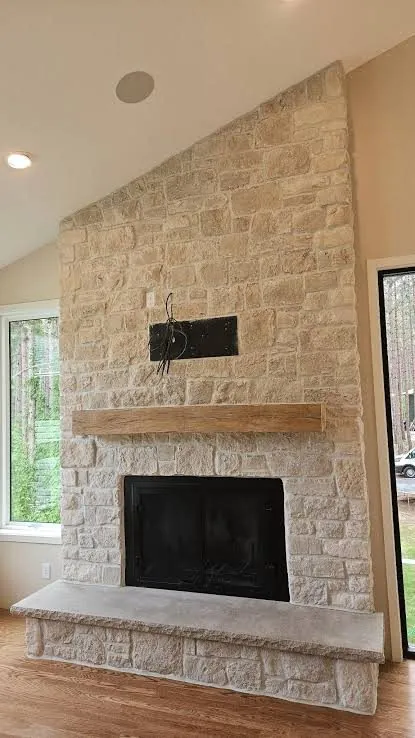 Light limestone veneer wall with raised hearth
