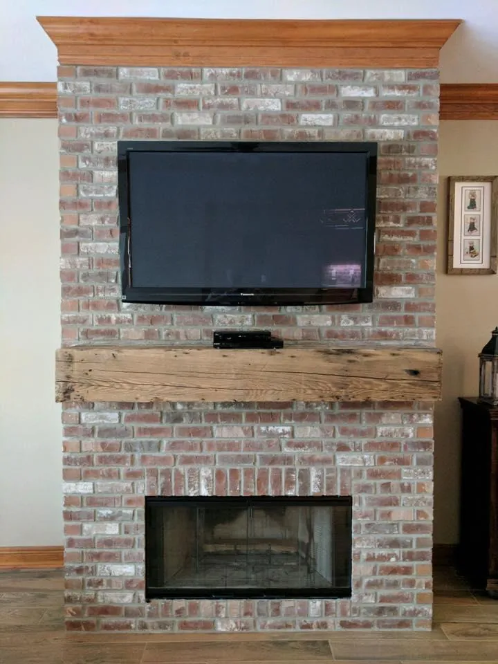 Red thin brick wall with a reclaimed wood mantel