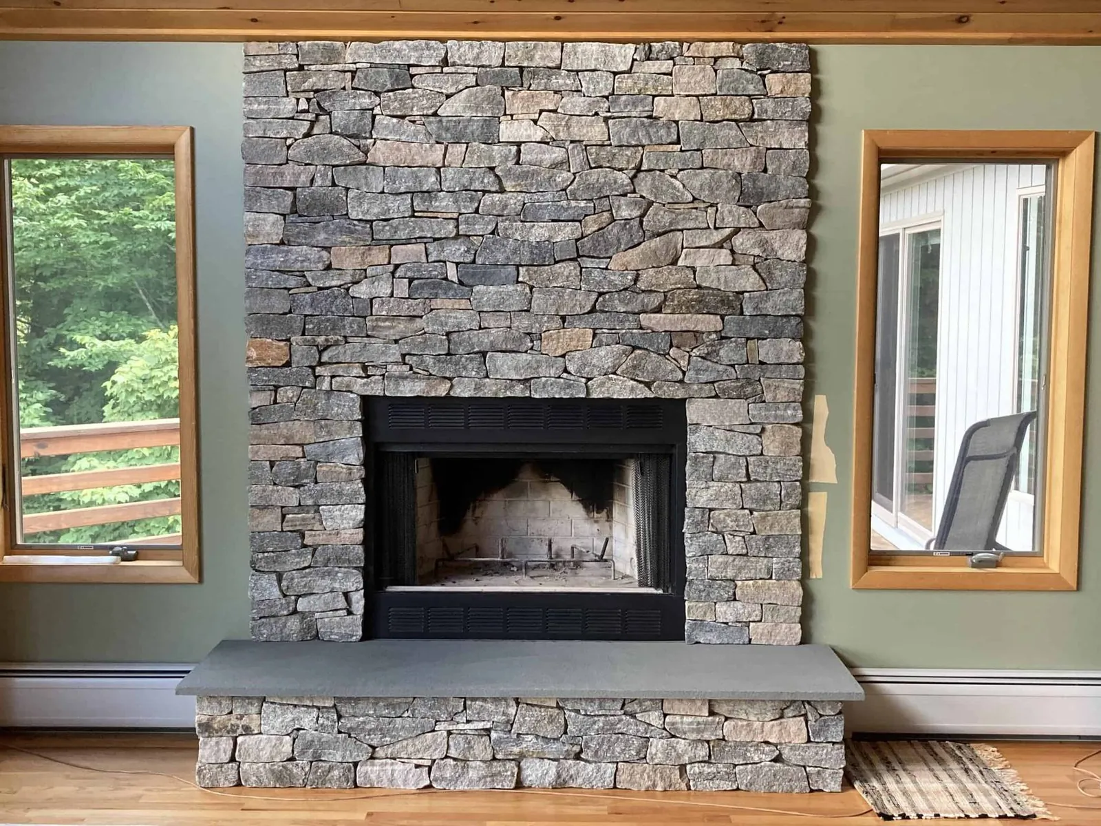 Stone veneer fireplace with bluestone hearth
