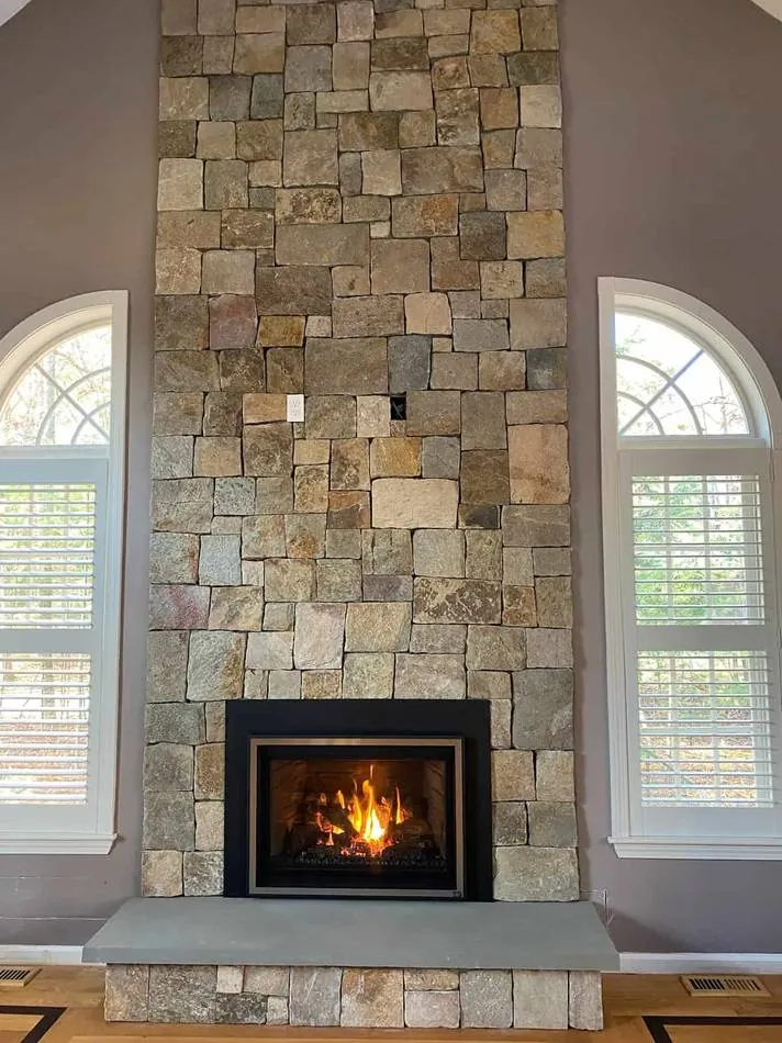 Stone veneer wall between arched windows